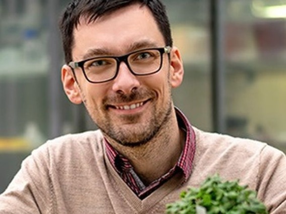 Filip smiling with a plant